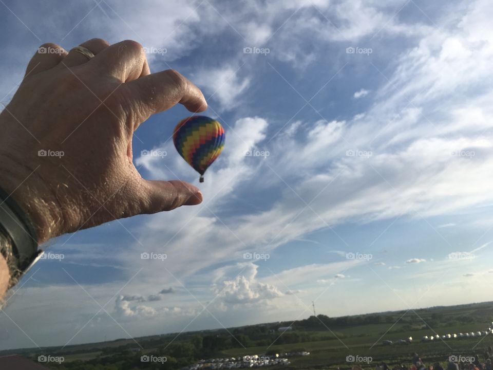 Holding a hot air balloon in your finger tips.