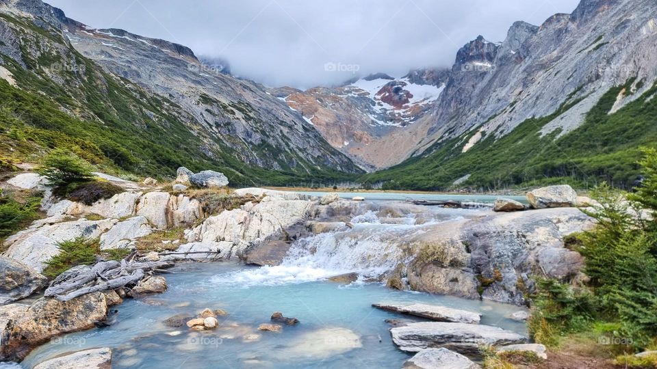 Laguna Esmeralda, Tierra del Fuego, Argentina. Light blue lagoon sourrounded by mountains and green trees.