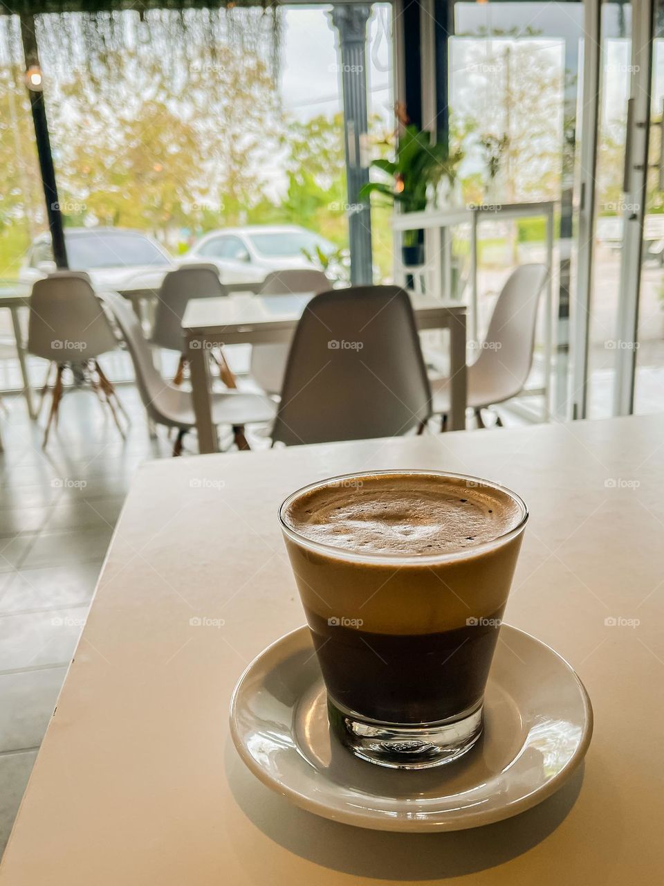 A cup of cappuccino on a white table top in a cafe