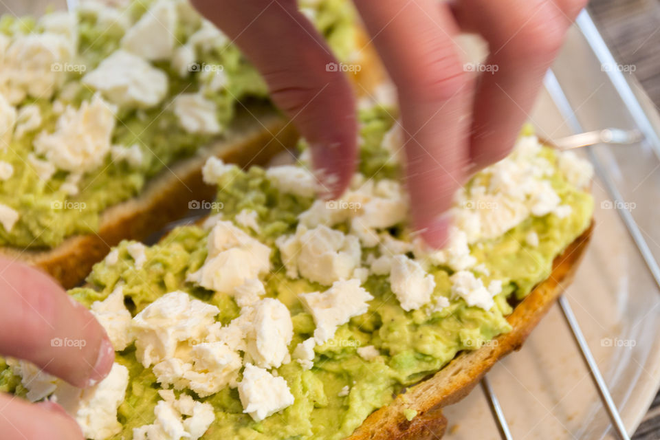 Preparing healthy breakfast - avocado feta toast 