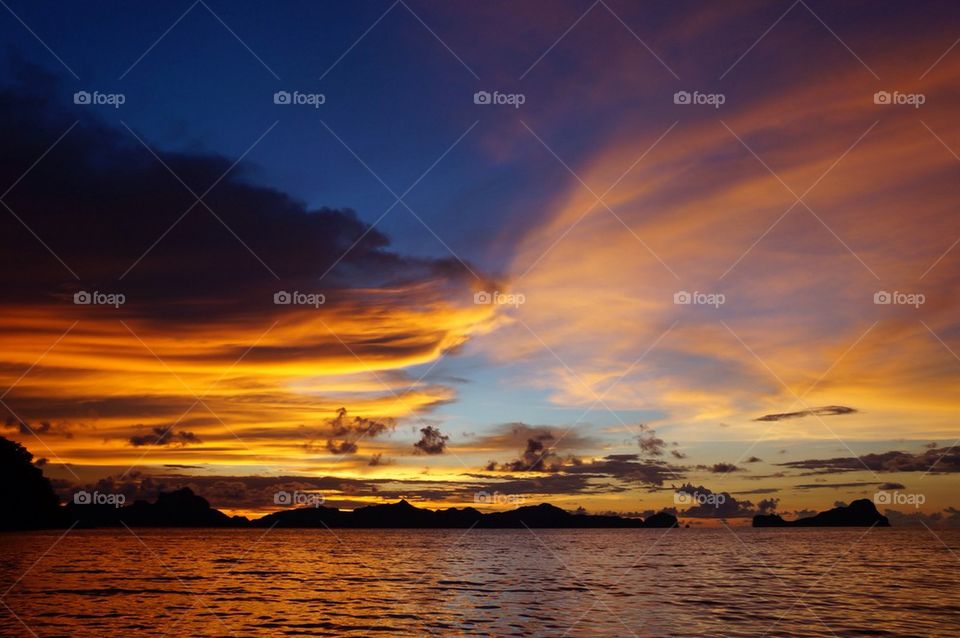 Cloudy sky over calm sea at sunset