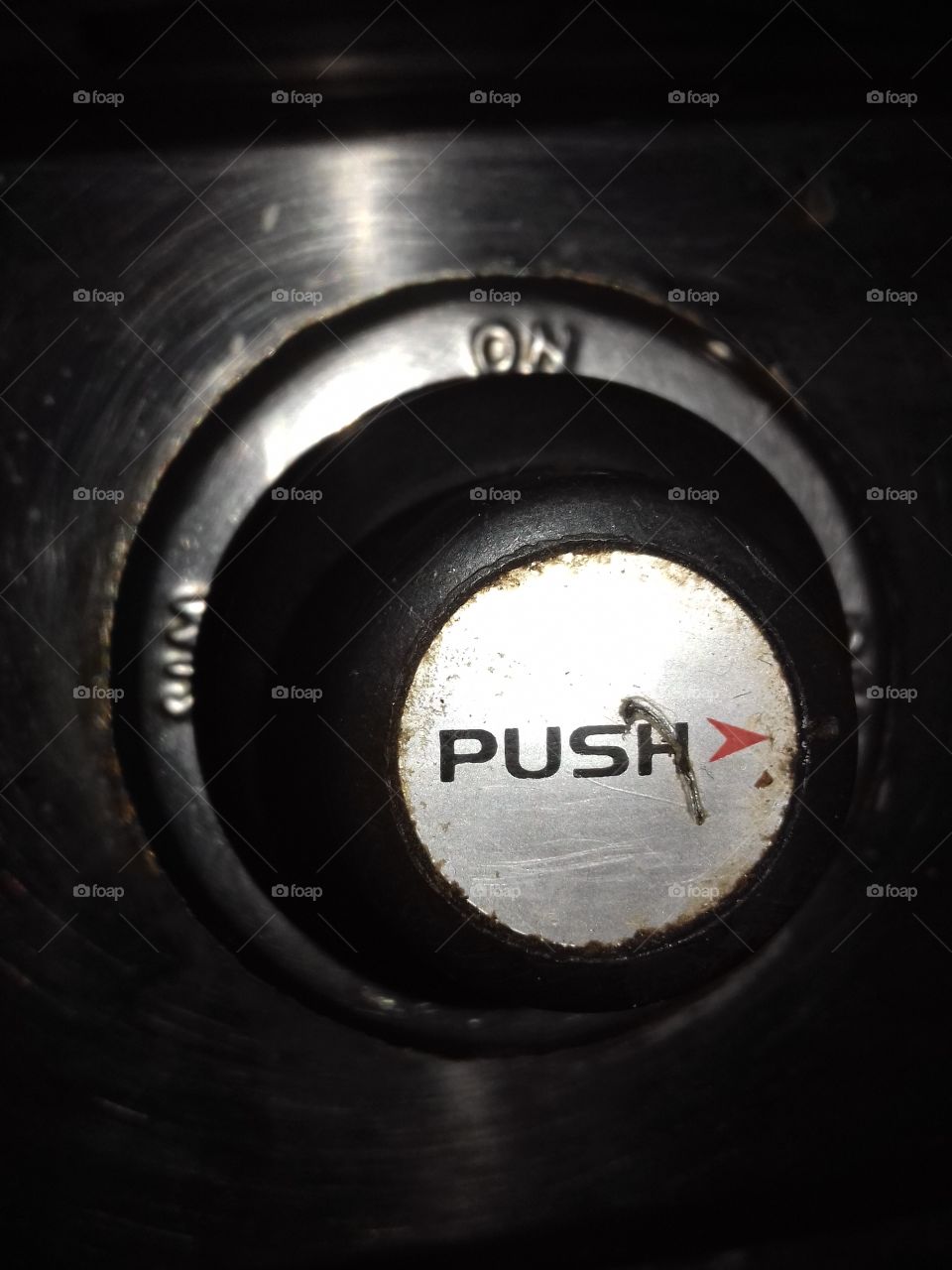 push button on gas stove old but in use and noticeable is the red indication depicting direction