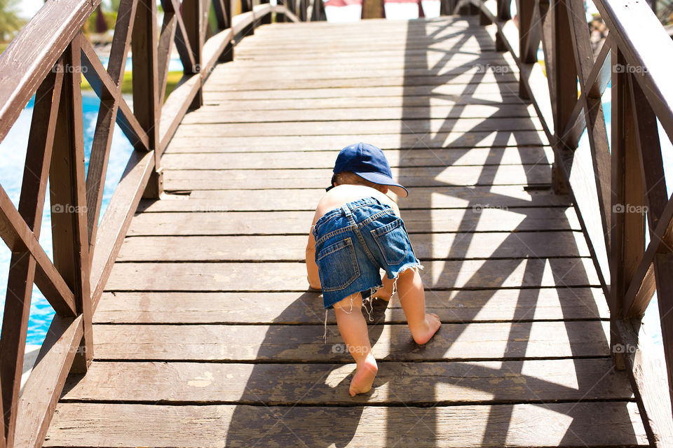 Baby crawling on footbridge