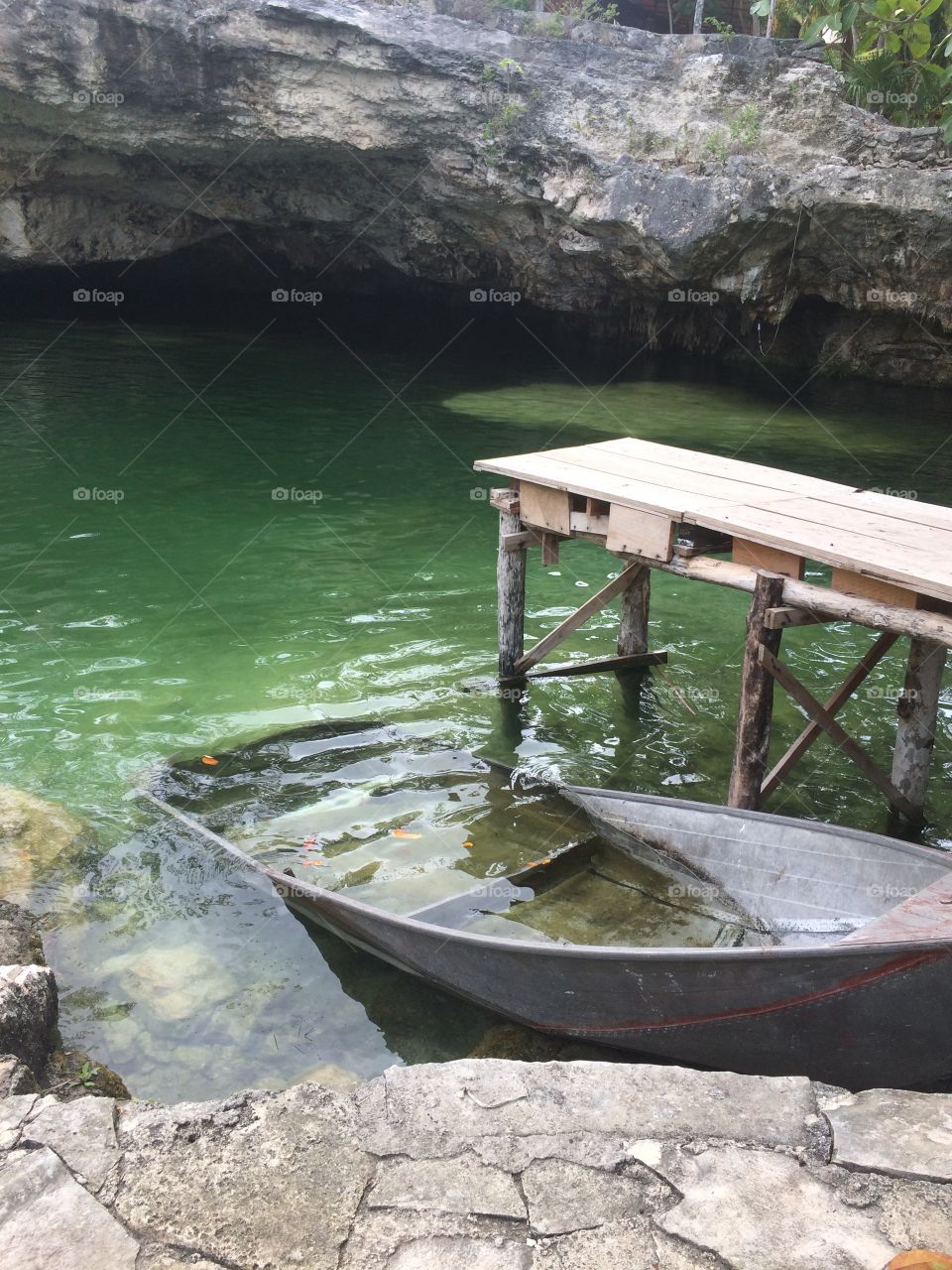 A sunken boat in a cenote in Tulum, Mexico.   A boat who has seen better days but made a great picture.