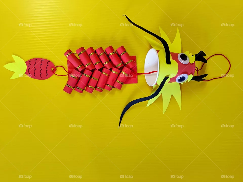 A Handmade Chinese Dragon Hanging Decoration with yellow background.The rule of thirds.