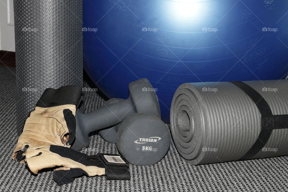 Pilates ball, yoga mat, foam roller, weights and gym gloves for exercise