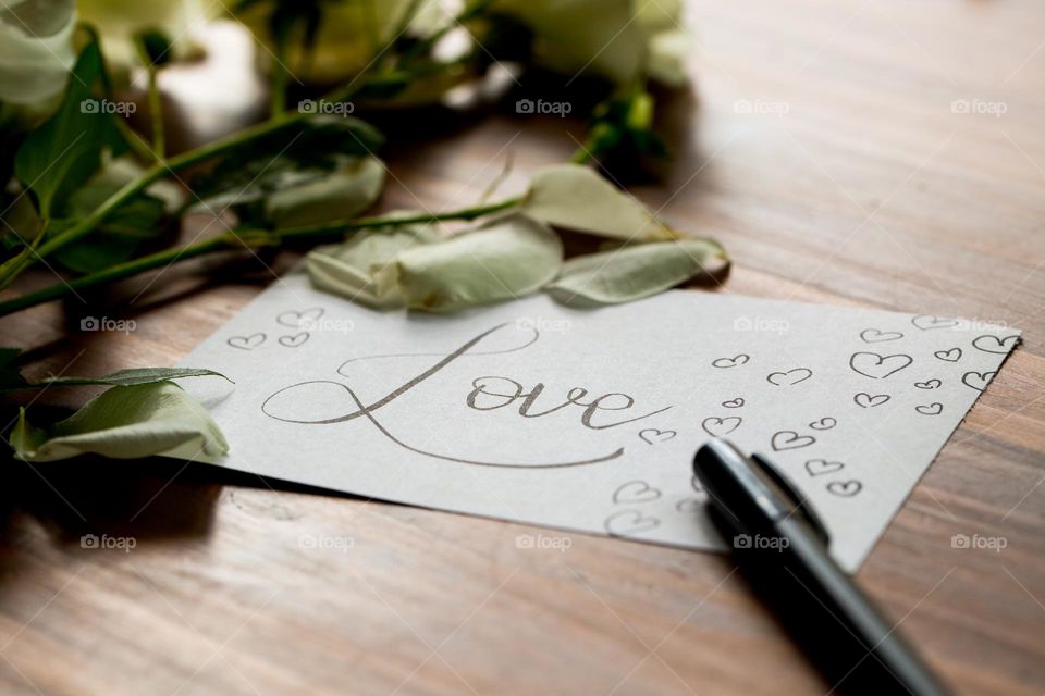 Love, photographed - a handwritten love note with flowers, petals and pen