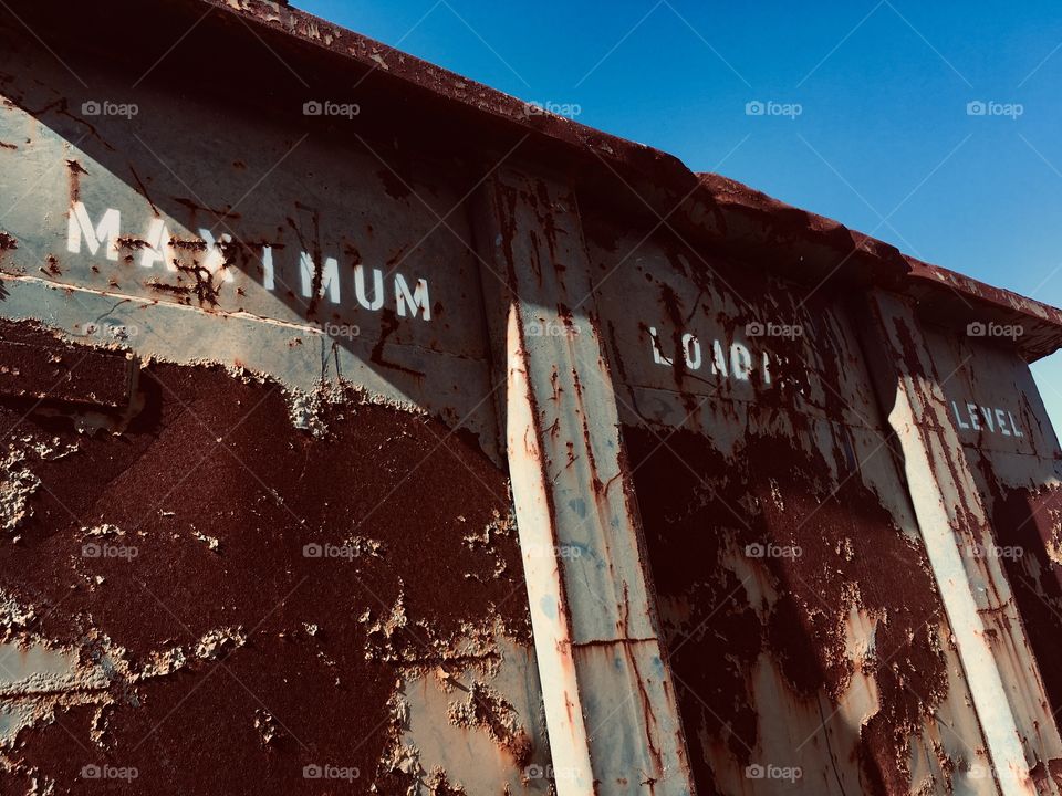 Maximum Load Level rusty dumpster 