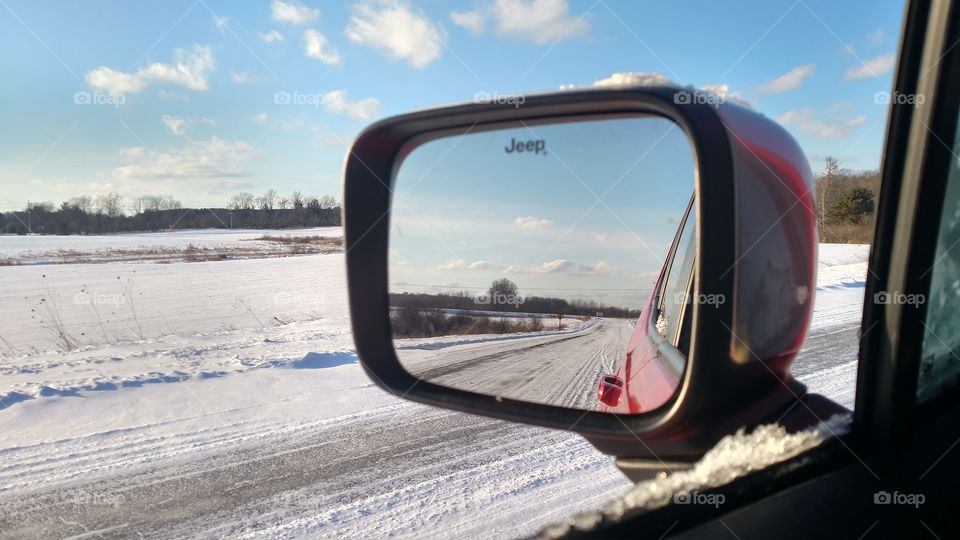 I was driving down a country road and the sky was beautiful. I stopped and looked out my mirror and loved the reflection.