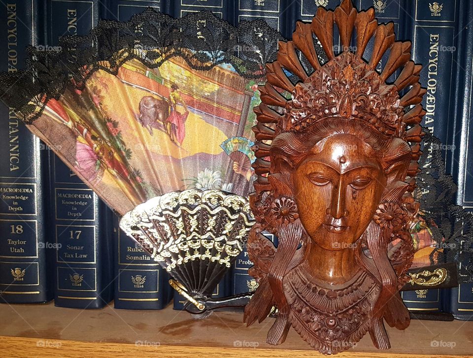 Baldness and Spanish travel souvenirs.  one is a fan the other a miniature sculpture