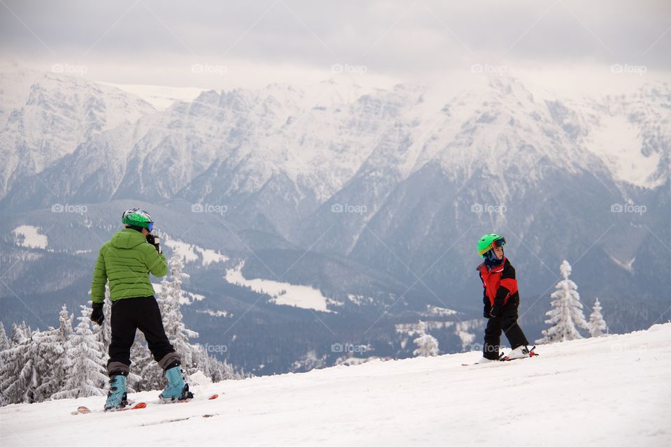 Woman and children skiing in Peak Postavarul , Poiana Brasov, Romania 