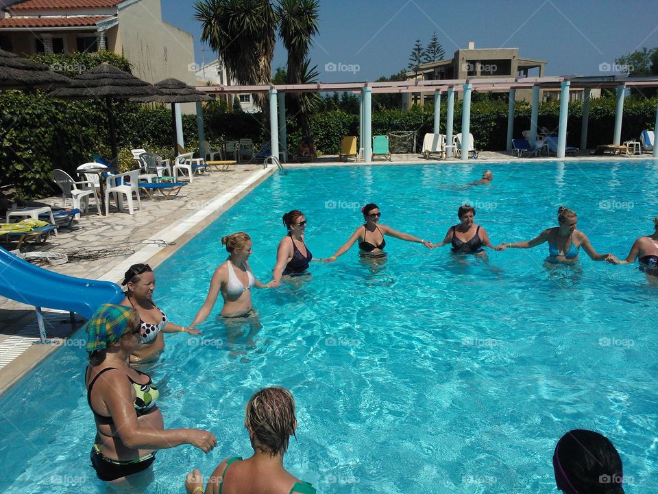 Woman's in swimming pool holding hand each other