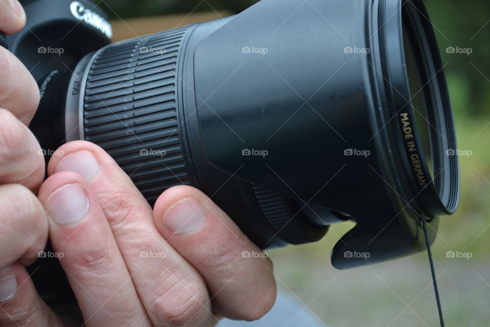 Closeup, photographer with camera focusing with zoom lens 