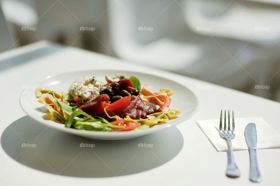 close-up of a young man eating a salad in a light kitchen