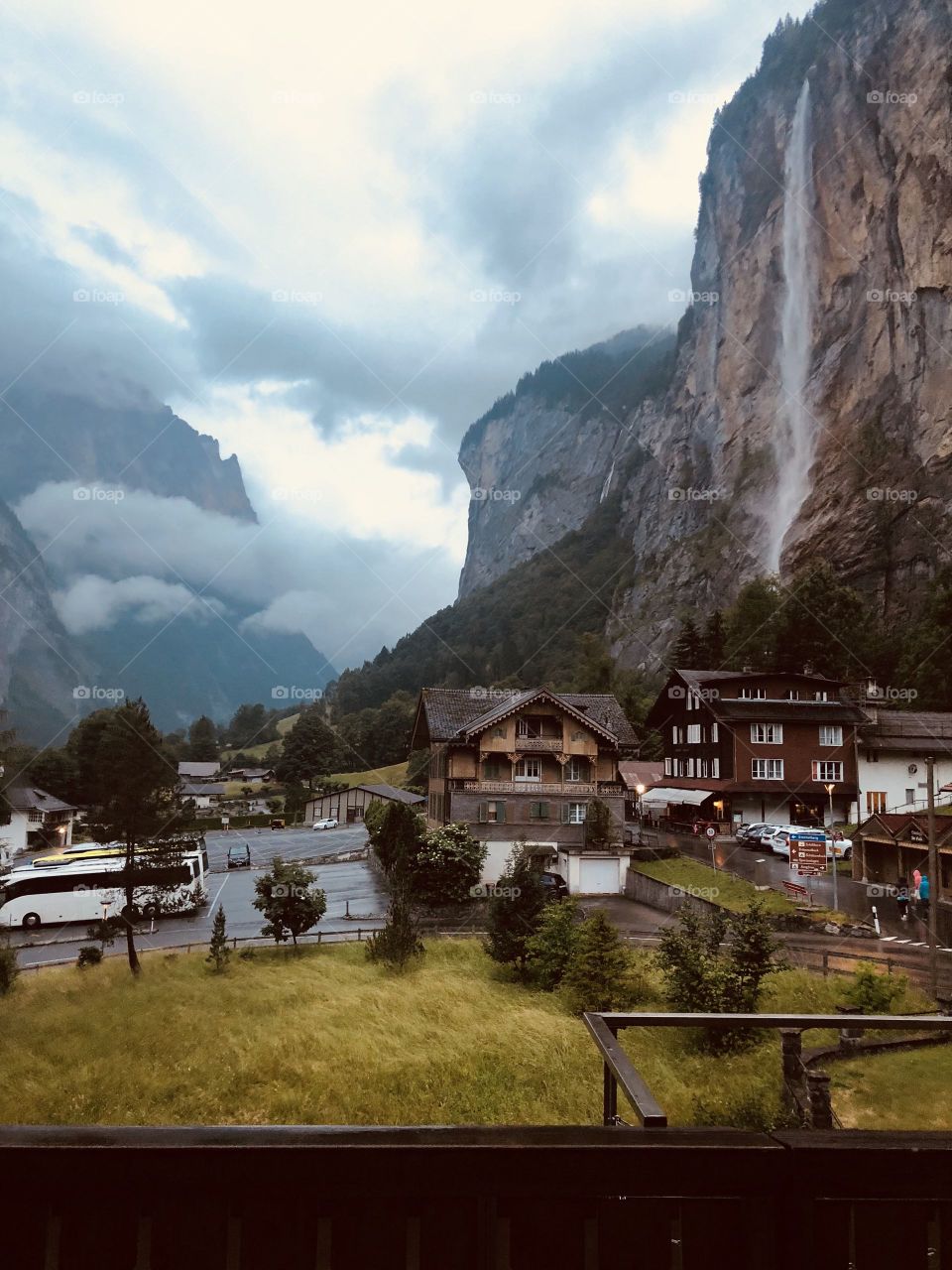 Dark Lauterbrunnen with a view of a beautiful and obscure waterfall off a mountain. Huge houses and great tourist view.
