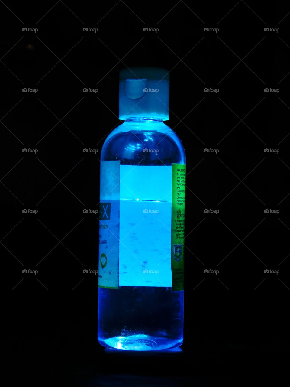 Blue Coloured lighting effect on sanitizer bottle having black background