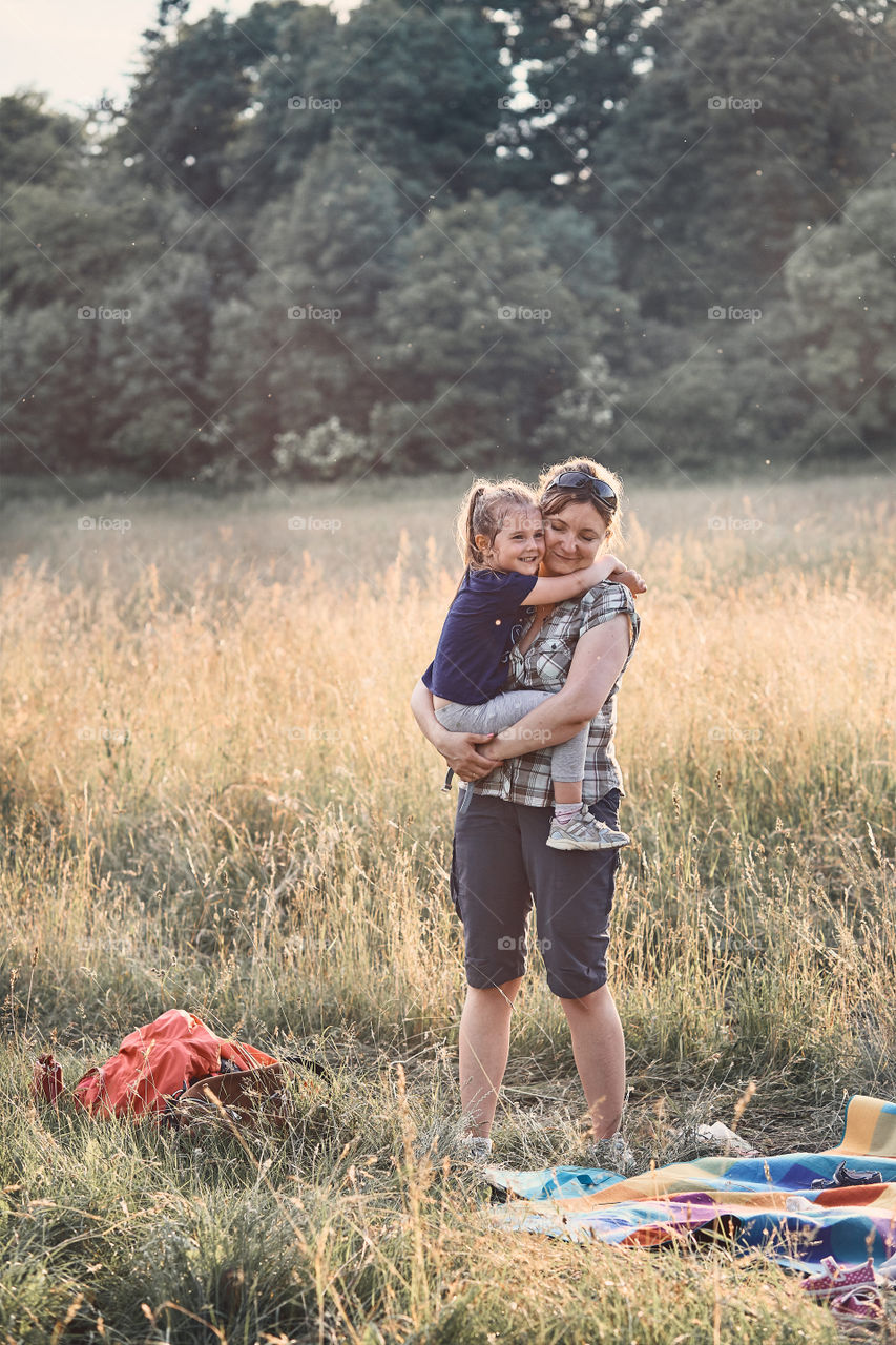 Family spending time together on a meadow, close to nature, parents and children playing together, making coronet of wild flowers. Candid people, real moments, authentic situations