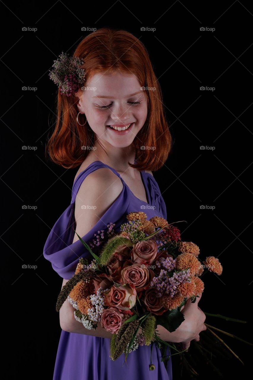 Beautiful young teen girl . 
Holding some flowers. Shes happy and still a Child, but also a young woman.