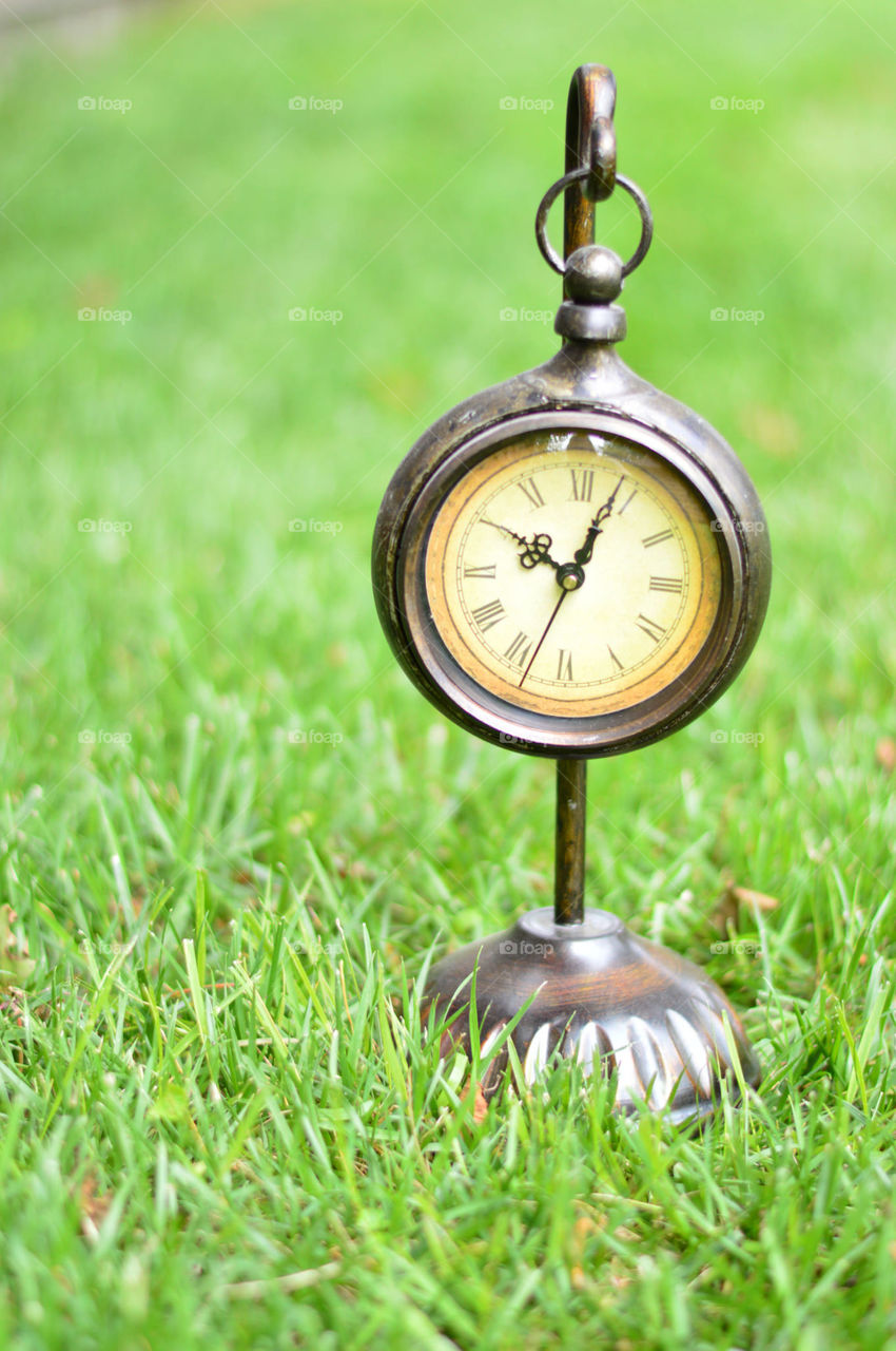 clock outside on the grass