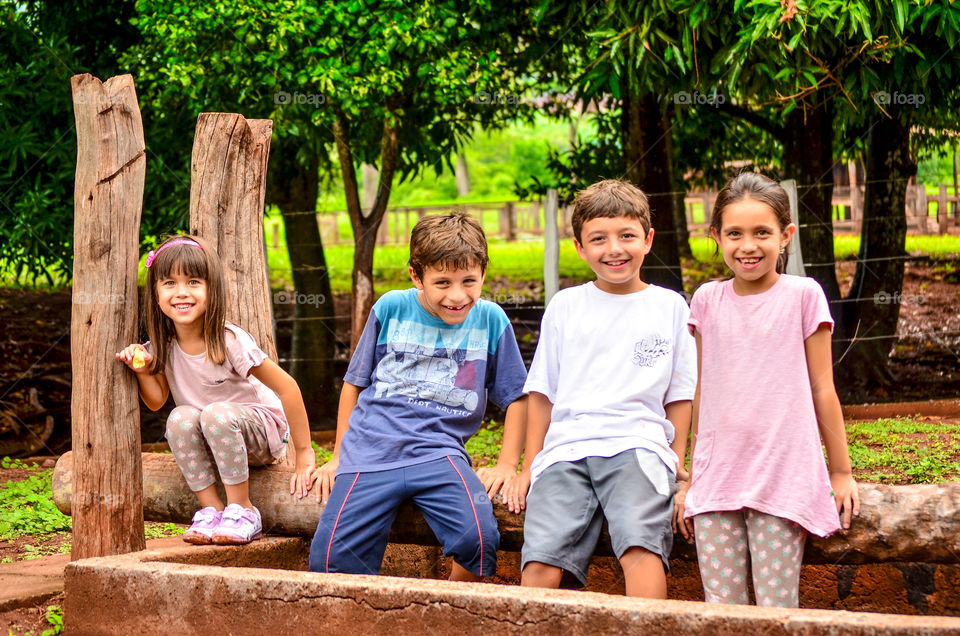 Children sitting on log in the park