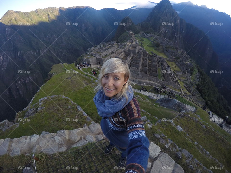 Woman standing in front of Macchu Picchu ruins