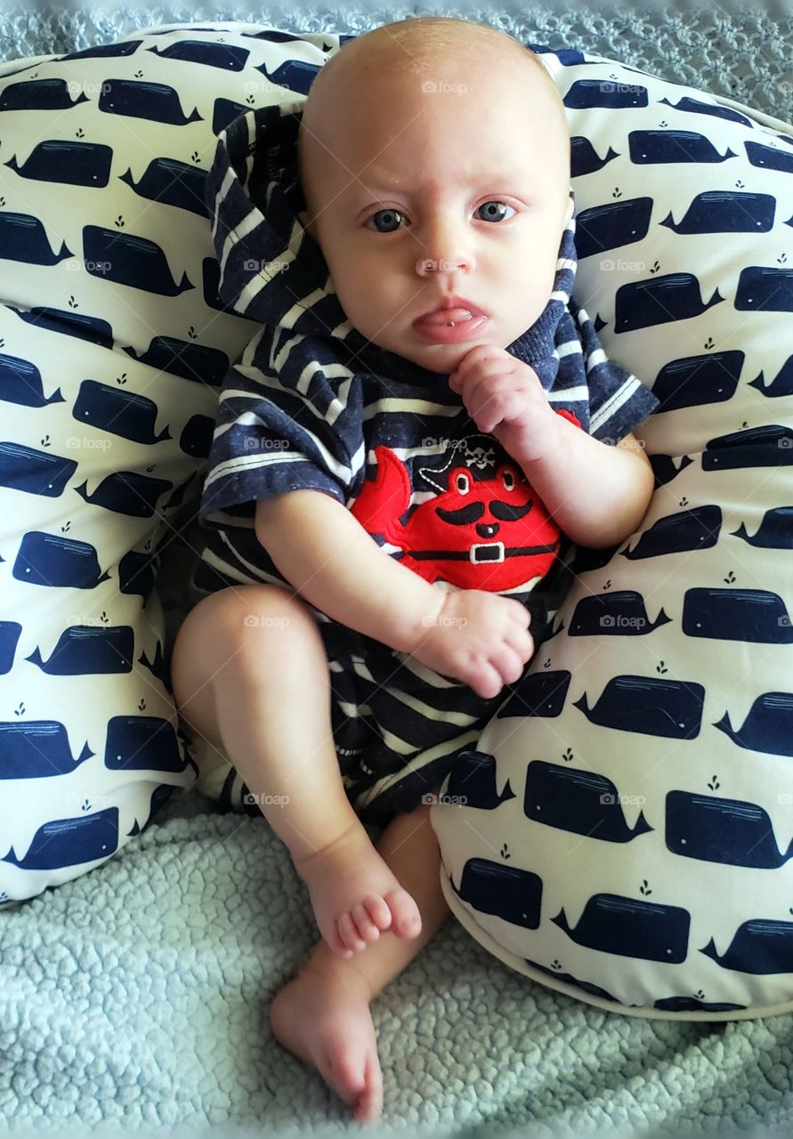 Adorable baby boy contemplating on who knows what.