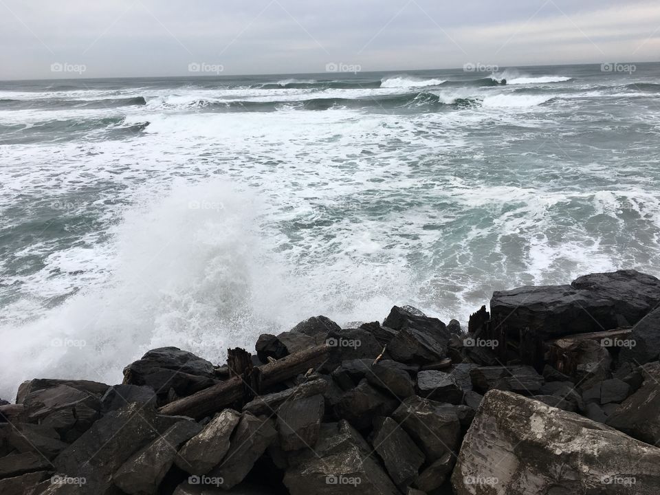 Scenic view of waves crashing against rock 