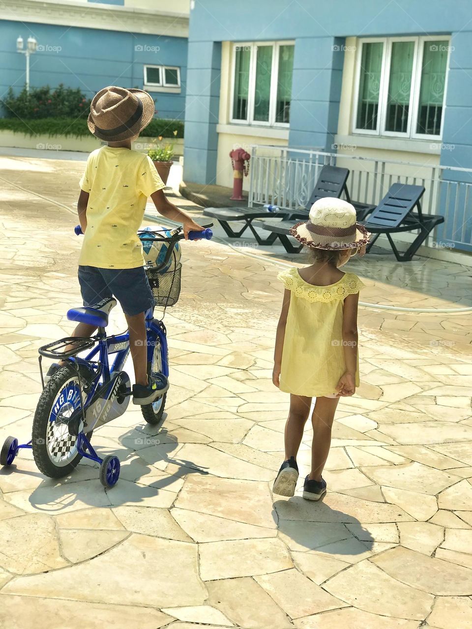 Brother and sister wears yellow colour outfits and going towards the swimming pool 