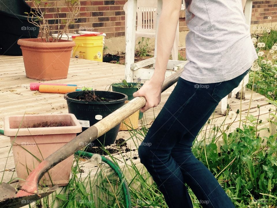 Wants to plant a tree. Girl trying to lift shovel 