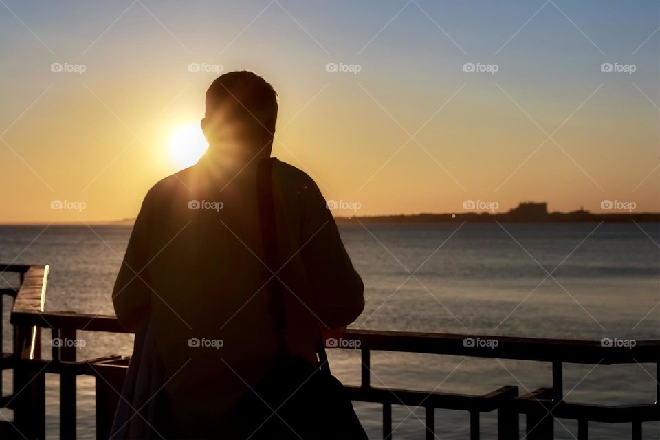 Back view of man looking at sunset