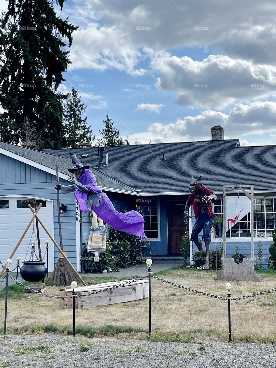 Witch with broom, witch brew, coffin, werewolf and guillotine next to the house. Halloween decor 