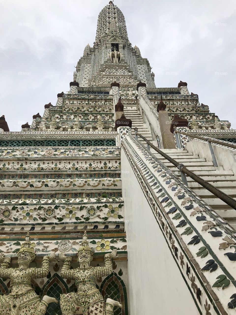 Wat Arun temple in Bangkok, Thailand, decorated and engraved temple pagoda stairs and statues 