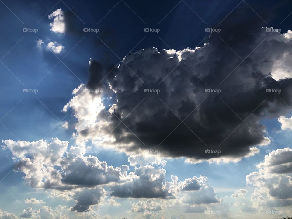 Sun behind the clouds in a warm Autumn afternoon... the contour of the clouds marked by the sun light is beautiful and terrifying, as it emphasizes the dark cloud promising rain...