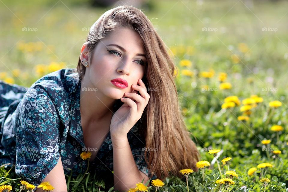 Beautiful young woman lying on meadow