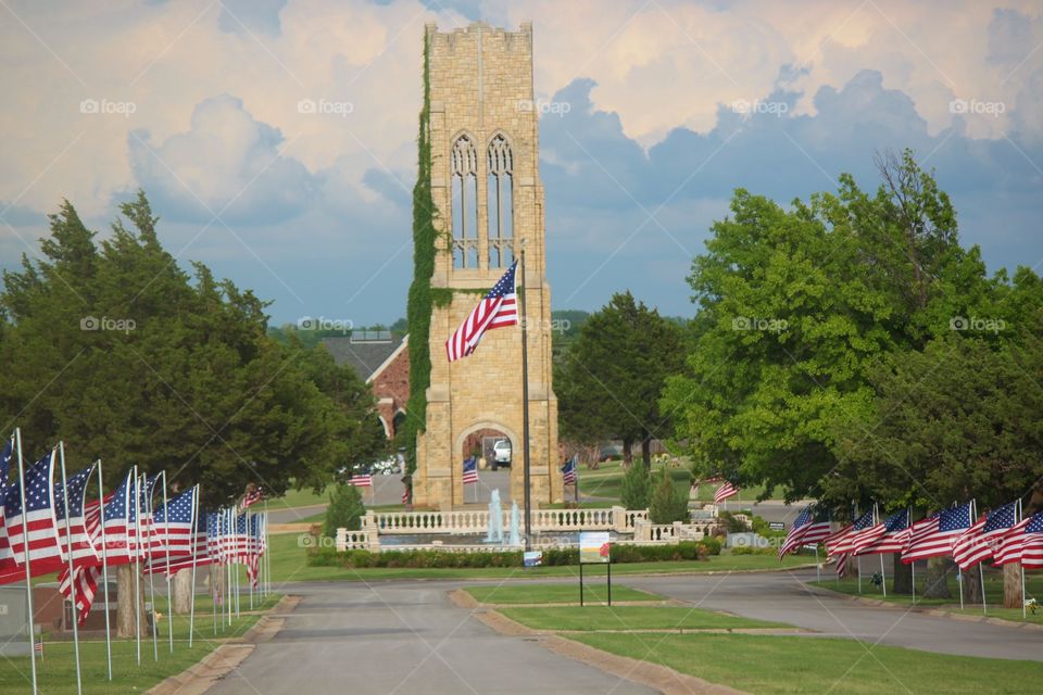 Cemetery with Tall Vintage Building with Rows of American Flags