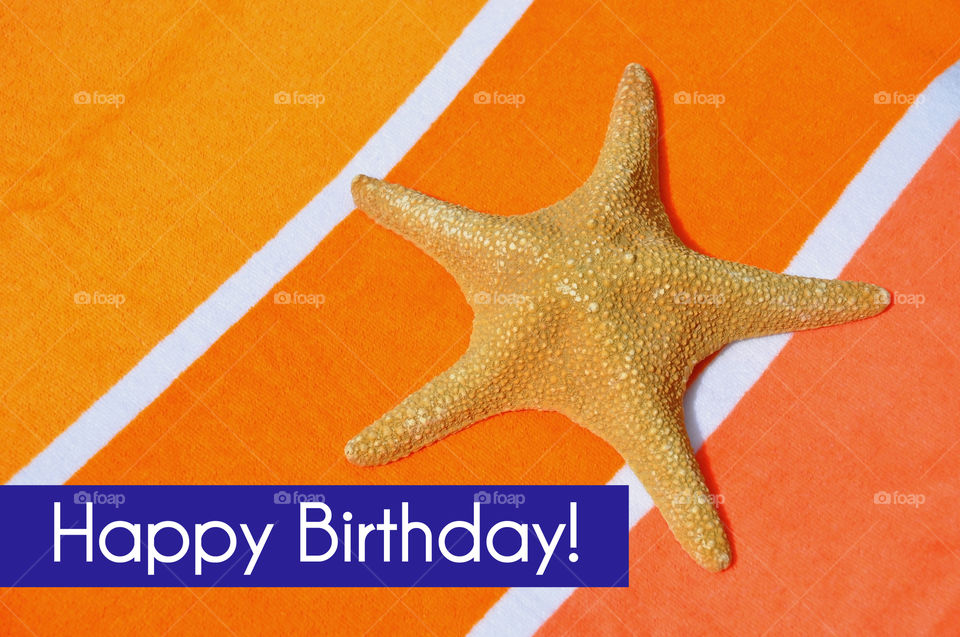 Happy Birthday concept. Starfish on a pretty orange background.