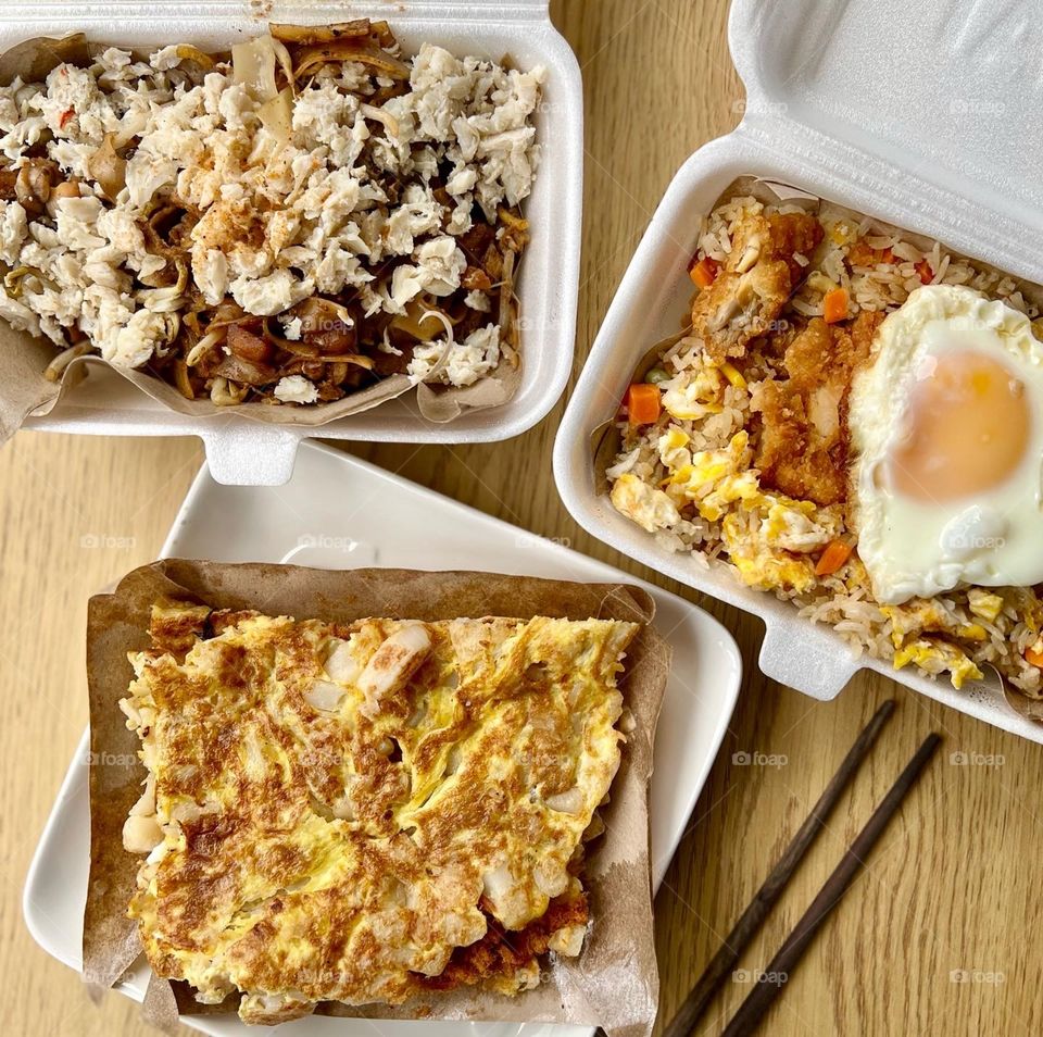 Local hawker asian dishes in cheesy floss carrot cake, crab meat char kway teow and fried rice with chicken and egg