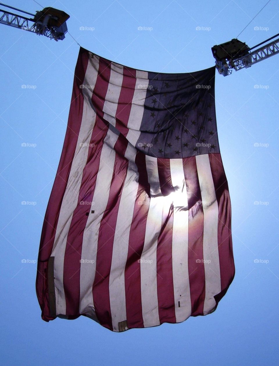 Flag hanging from two ladder firetrucks