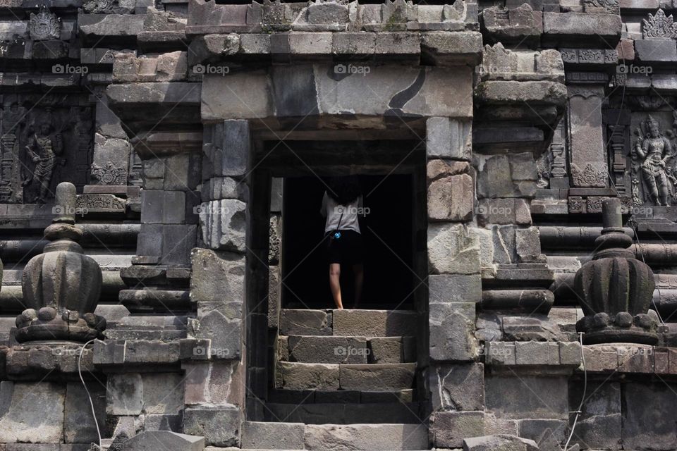 One of the temples in the Prambanan Temple Complex, with a stone relief on the wall of the temple which is part of the largest Hindu temple in Southeast Asia, Yogyakarta, Indonesia - June 23, 2023