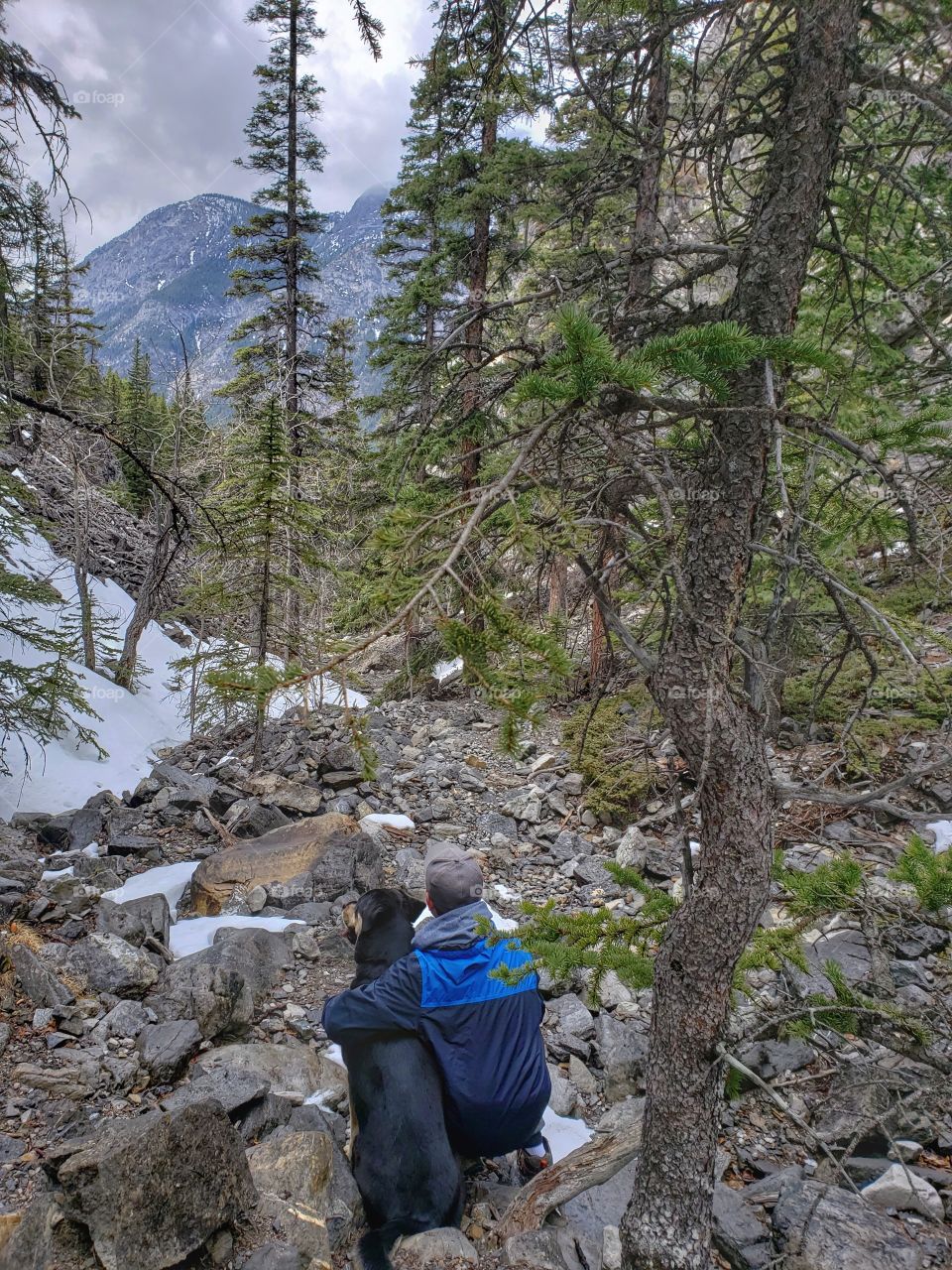 Man and His Best friend looking down the thawing trail