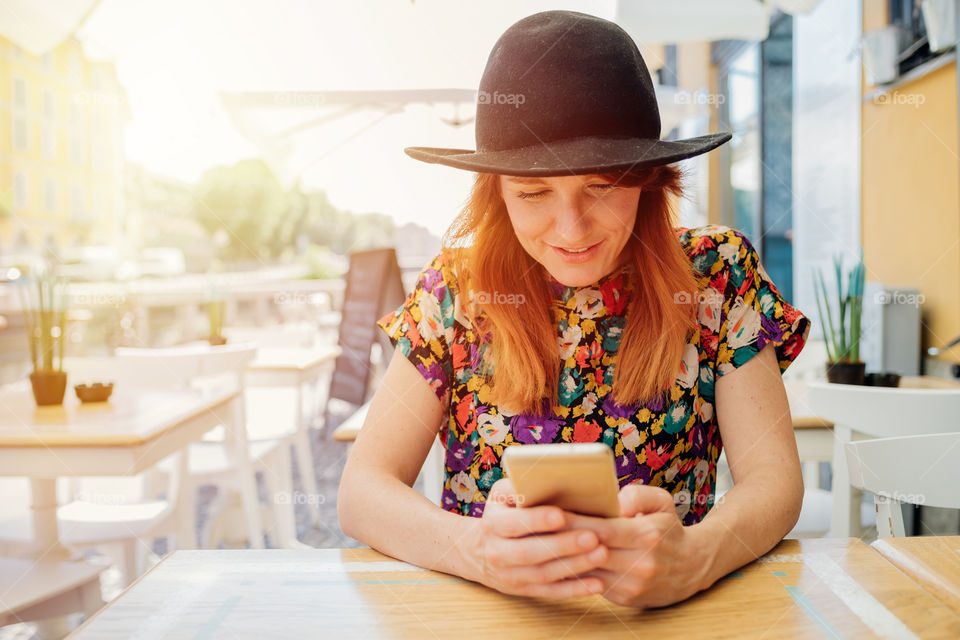 beautifull woman using smartphone sitting at the bar outdoor - communication, social life, smart working