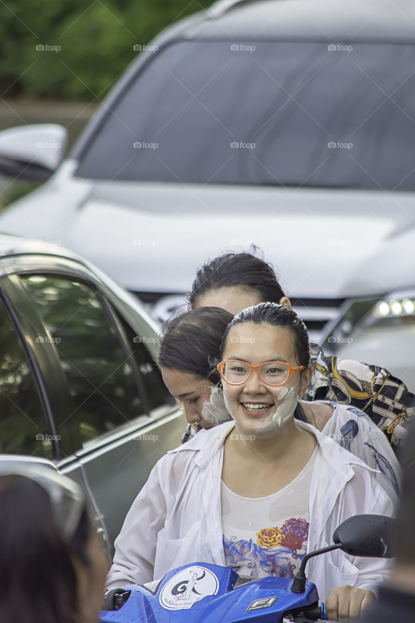 Asian woman Riding a motorcycle play water and flour in Songkran festival or Thai new year in Thailand at Bang kruai, Nonthaburi , April 15, 2019