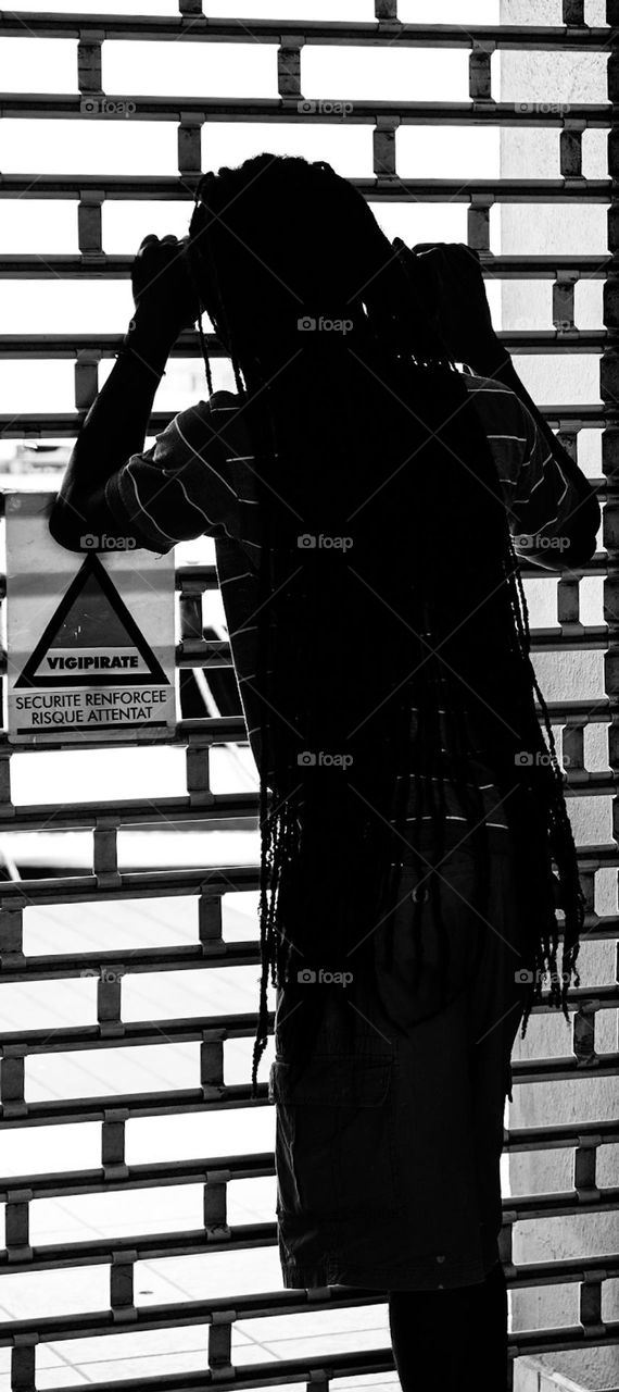 Man looks out of gate, man waits and looks through gate, waiting in line 