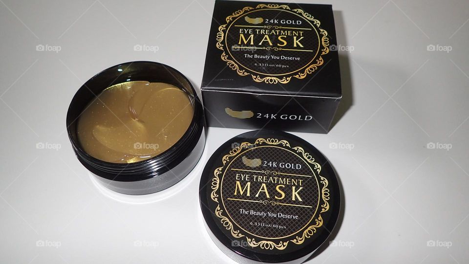 Beauty product I love Gold Eye Treatment Masks view from above open container golden masks visible next to top and box against clean white background 