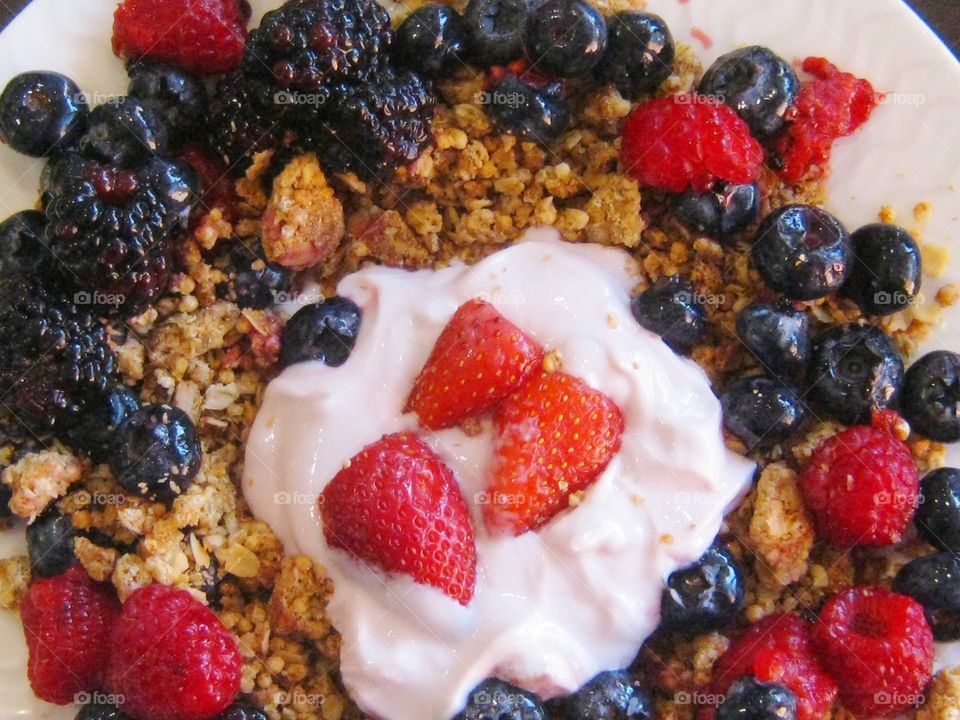 close-up overlay strawberries raspberries blueberries blackberries and granola and yogurt