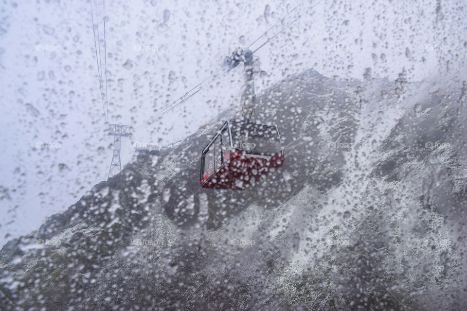 A cable car faintly seen through the snowfall