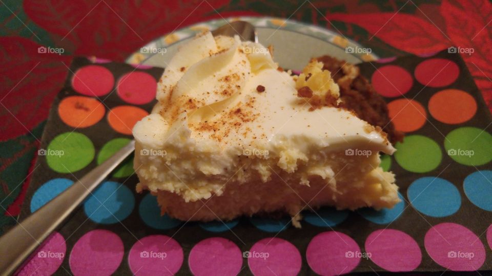 A slice of eggnog cheesecake on a polka dot napkin.