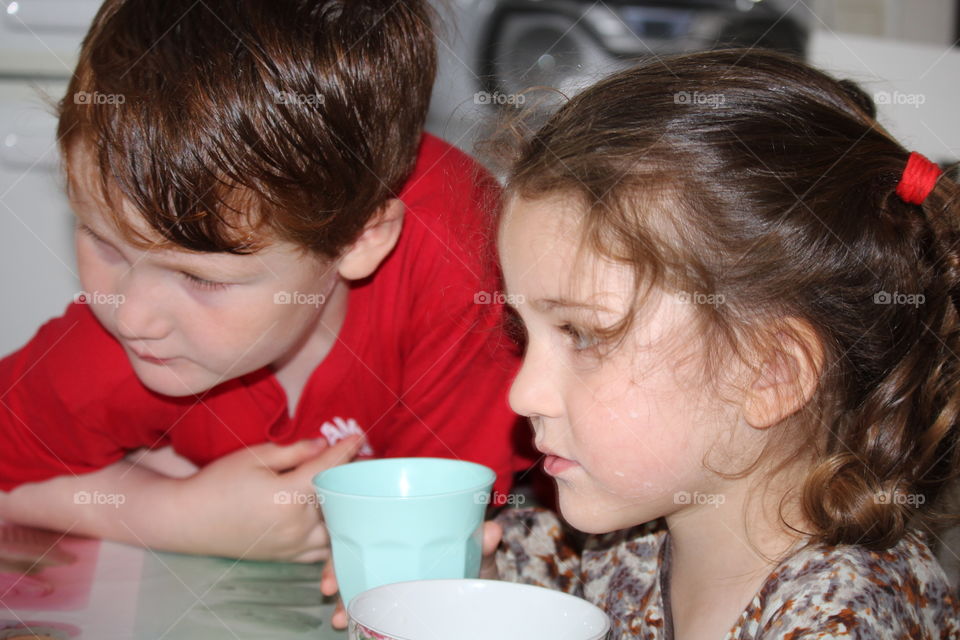 Sibling on dinning table with tea cup