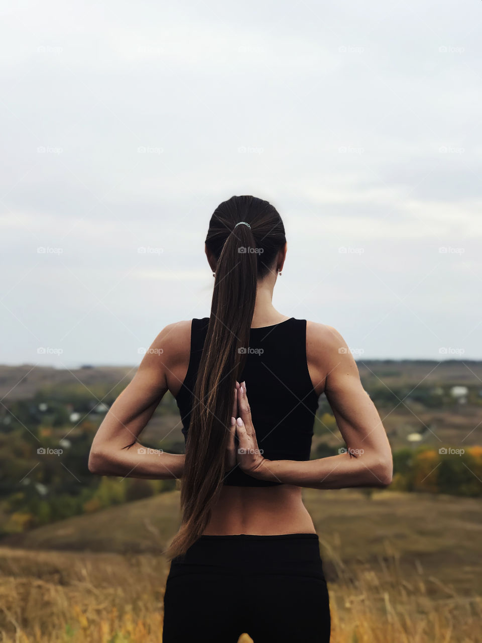 Young woman with long hair doing yoga outdoors 