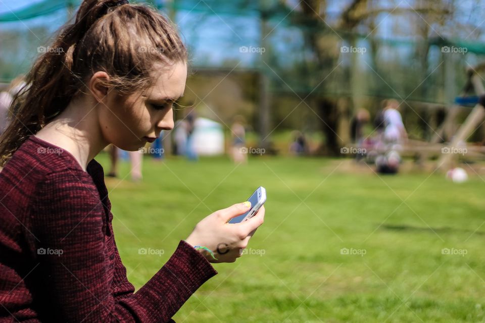 Side view of a woman using mobile phone